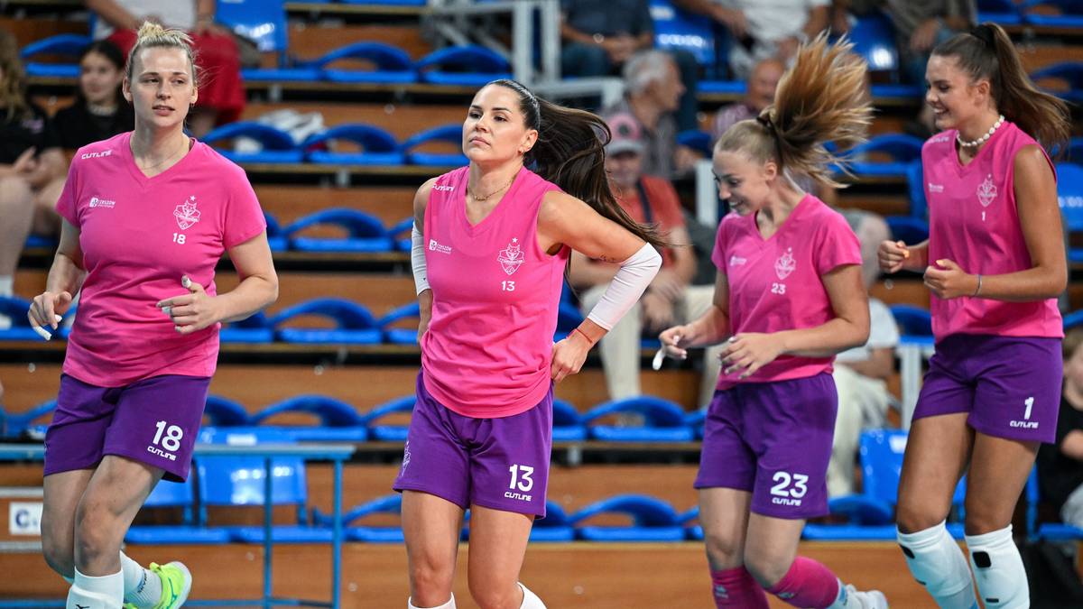 Cztery siatkarki w sportowych strojach biegną po boisku.