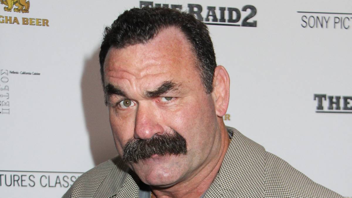 Don Frye pozuje z zaciśniętymi pięściami, ubrany w jasny garnitur.