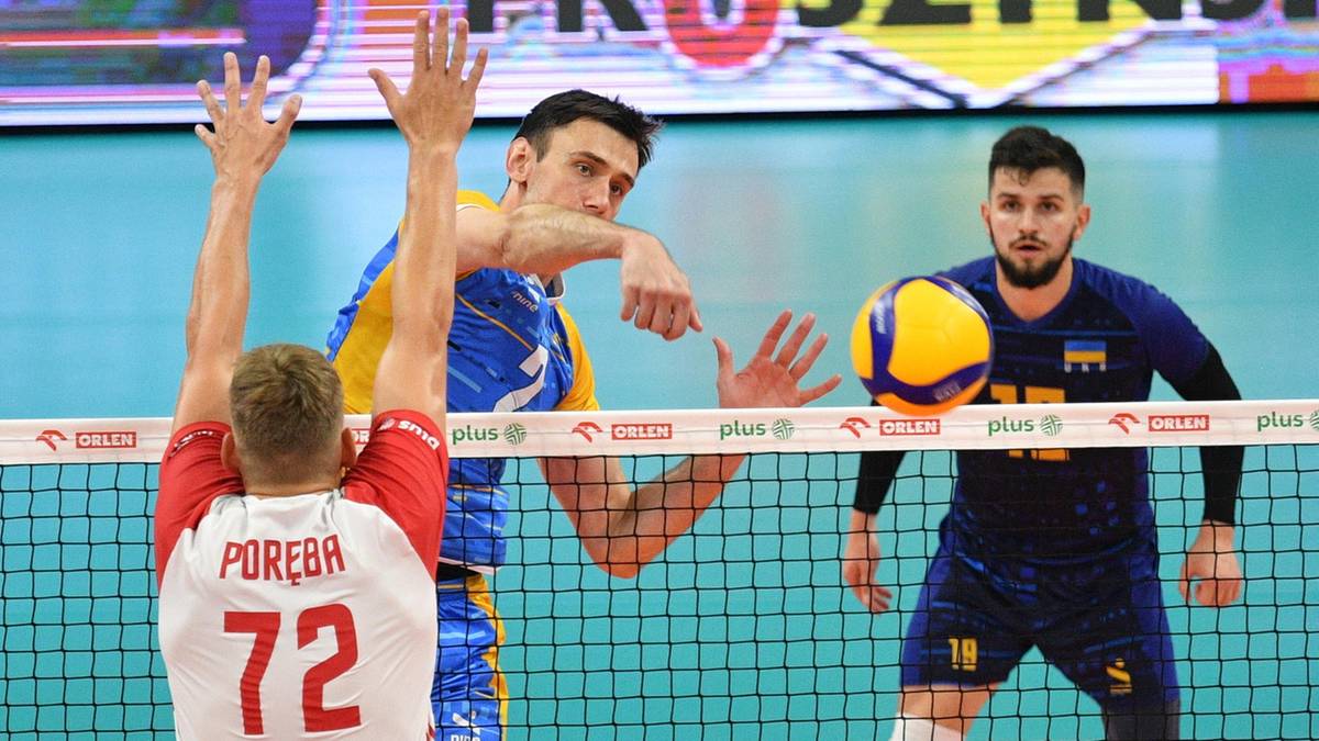 Trzech siatkarzy w akcji podczas meczu siatkówki, dwóch z nich blokuje atak przeciwnika.