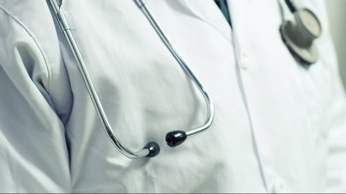 Zbliżenie na biały fartuch lekarski ze stetoskopem, symbolizującym opiekę medyczną.