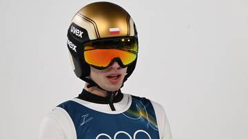 Mężczyzna w kasku i goglach narciarskich, ubrany w str&oacute;j sportowy z logotypem igrzysk olimpijskich.