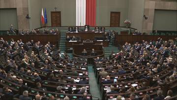 Widok z góry na salę plenarną Sejmu podczas głosowania, z widocznymi rzędami posłów siedzących w ławach.