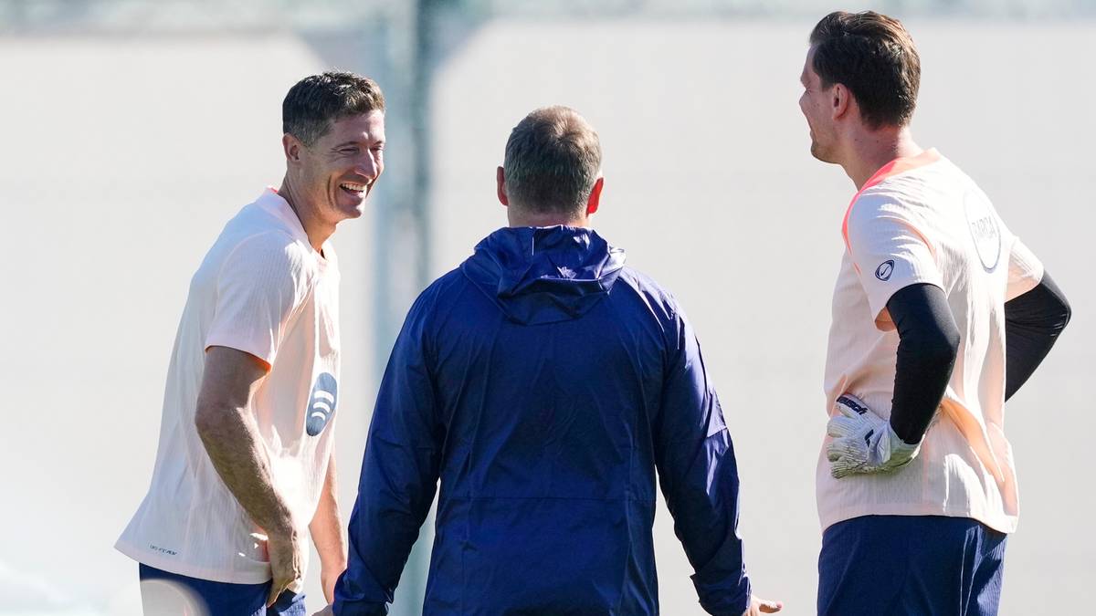 Trzech mężczyzn podczas treningu piłkarskiego, z których jeden to Robert Lewandowski.