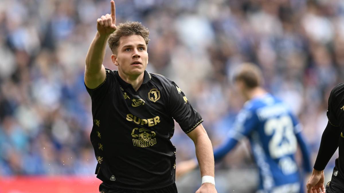 Młody piłkarz w czarnej koszulce z numerem 77 unosi palec do góry.