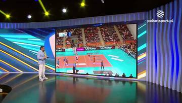 Jakub Bednaruk analizuje mecz siatkówki wyświetlany na dużym ekranie w studiu telewizyjnym.