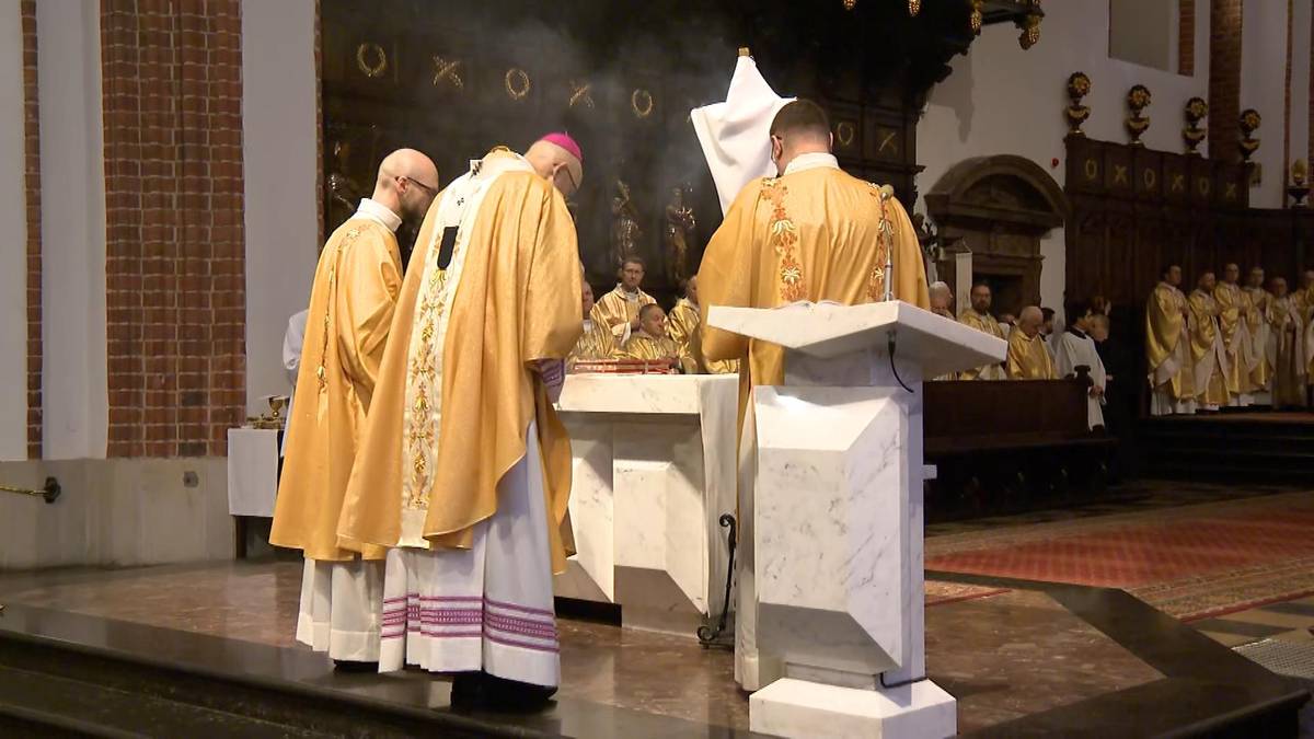 Trzech duchownych w szatach liturgicznych podczas uroczystości w kościele.