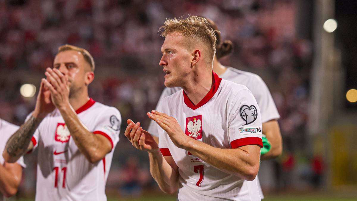 Trzech piłkarzy reprezentacji Polski w białych strojach, dwaj z nich klaszczą.