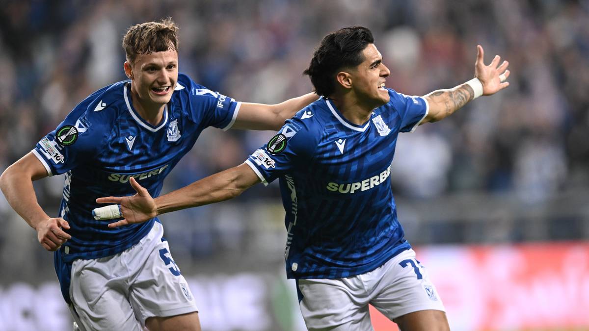 Dwóch piłkarzy Lecha Poznań w niebieskich koszulkach celebruje bramkę.