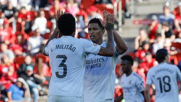 Dw&oacute;ch piłkarzy Realu Madryt w białych strojach świętuje podniesienie rąk, na tle publiczności na trybunach.