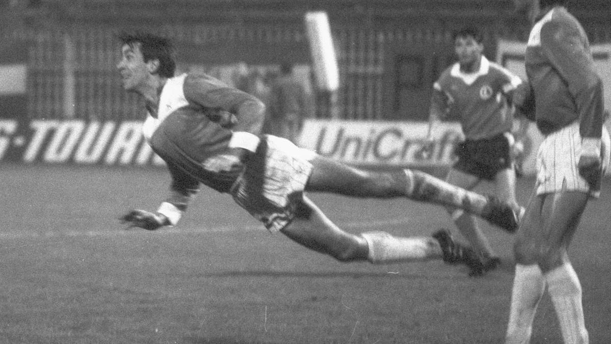 Piłkarze rywalizujący o piłkę na murawie stadionu piłkarskiego podczas meczu.