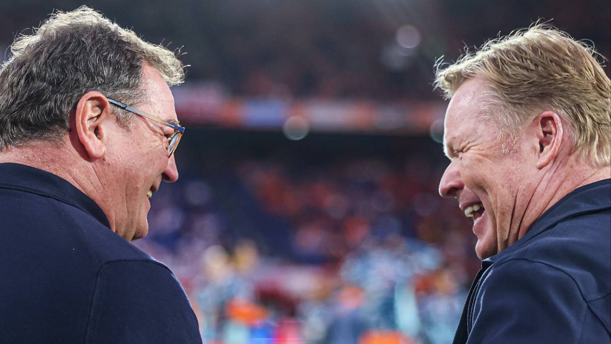 Dw&oacute;ch mężczyzn rozmawia i śmieje się na stadionie.