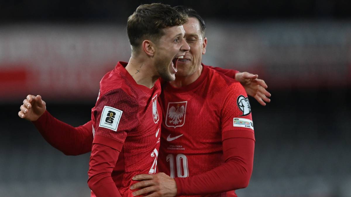 Dw&oacute;ch piłkarzy w czerwonych koszulkach reprezentacji Polski świętuje bramkę.