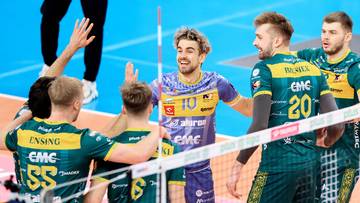 Siatkarze drużyny Aluron CMC Warta Zawiercie świętują zwycięstwo na boisku, podając sobie ręce.