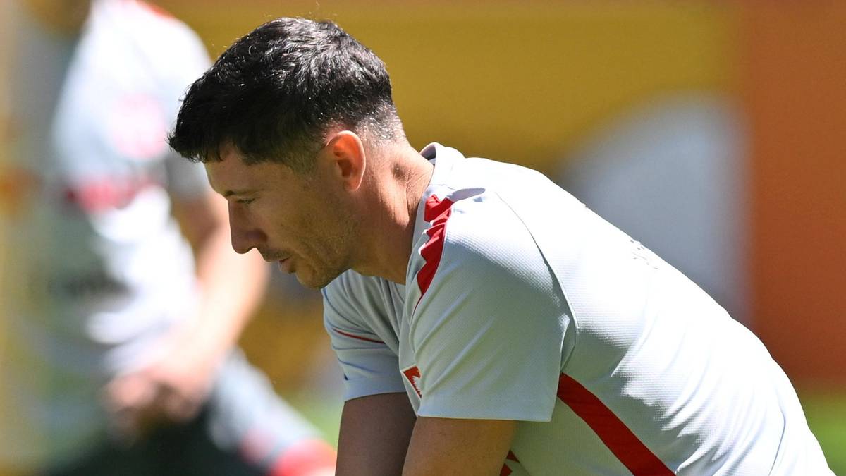 Robert Lewandowski w pozycji do ćwiczeń na boisku piłkarskim.