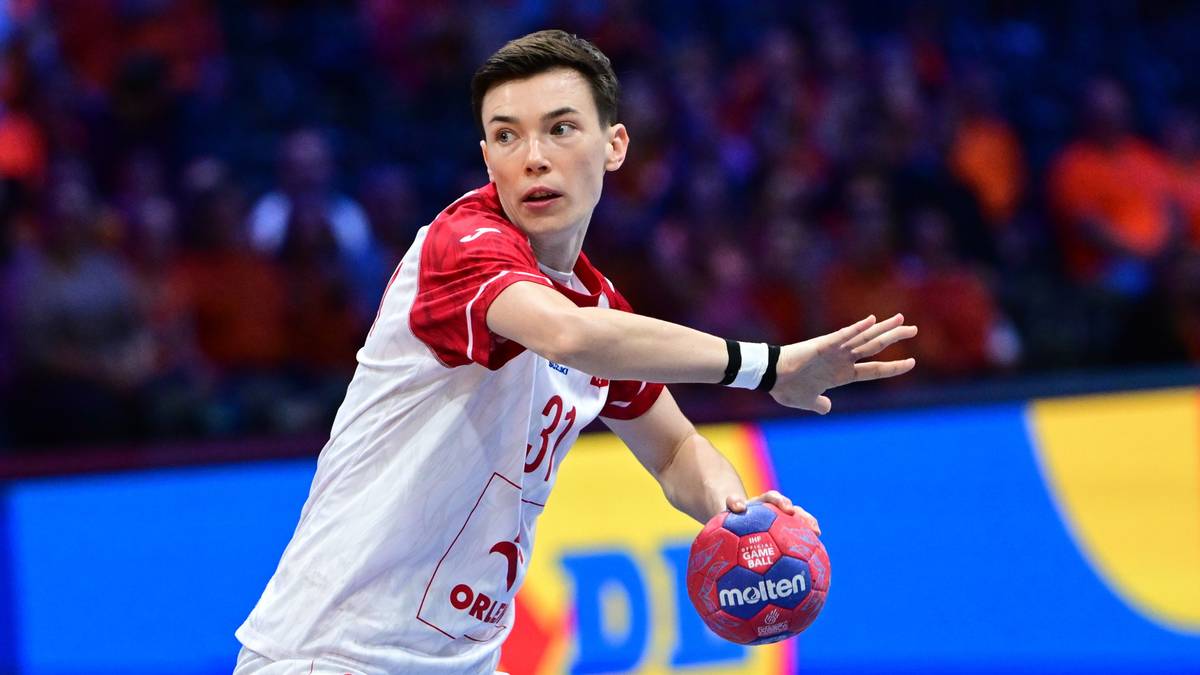 Piłkarka ręczna w białej koszulce z numerem 31 na boisku z piłką w dłoni.