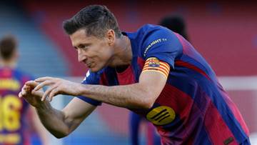 Piłkarz Robert Lewandowski w koszulce Barcelony z opaską kapitańską na ramieniu, świętuje zdobycie bramki.
