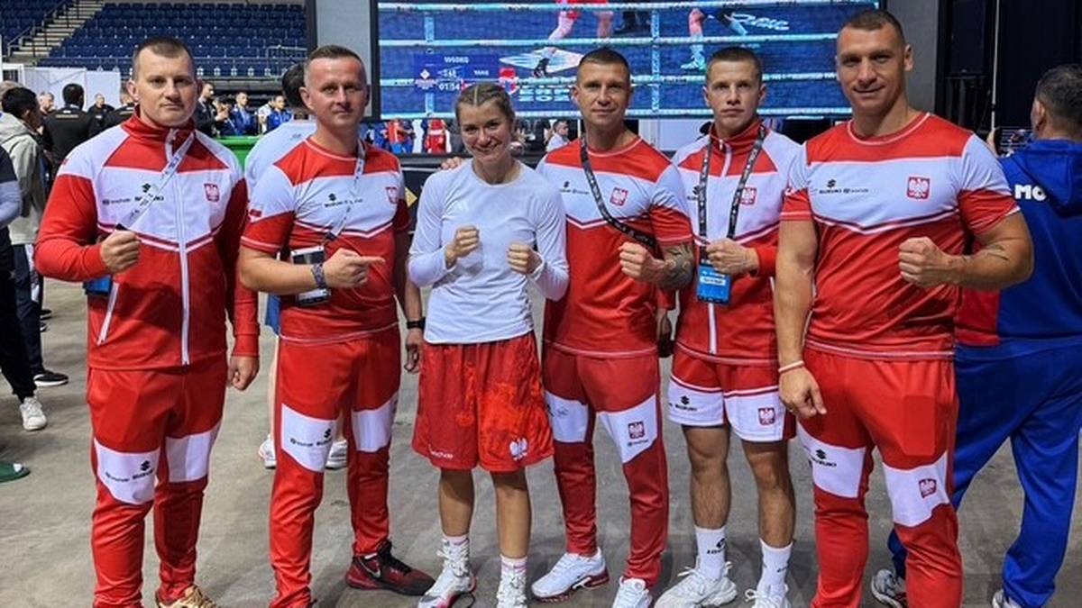Sześcioro sportowców w strojach bokserskich reprezentacji Polski, stojących obok siebie. Od lewej: czterech mężczyzn, jedna kobieta, jeden mężczyzna. Wszyscy uśmiechnięci.