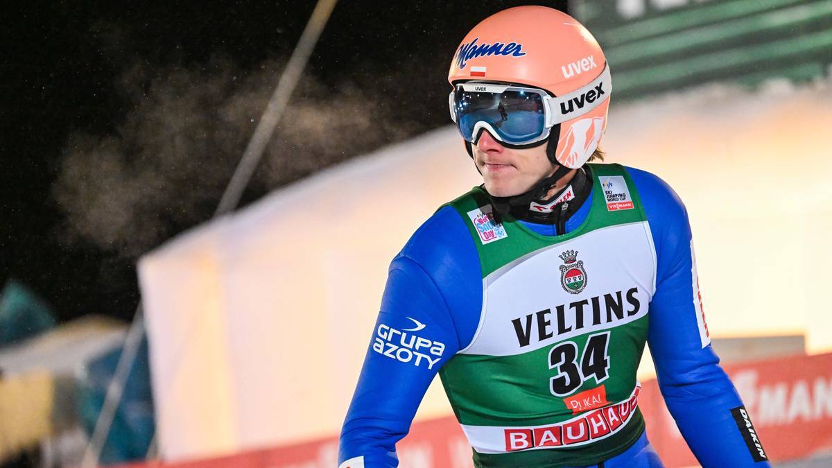 Skoczek narciarski w kasku i goglach przed zawodami.