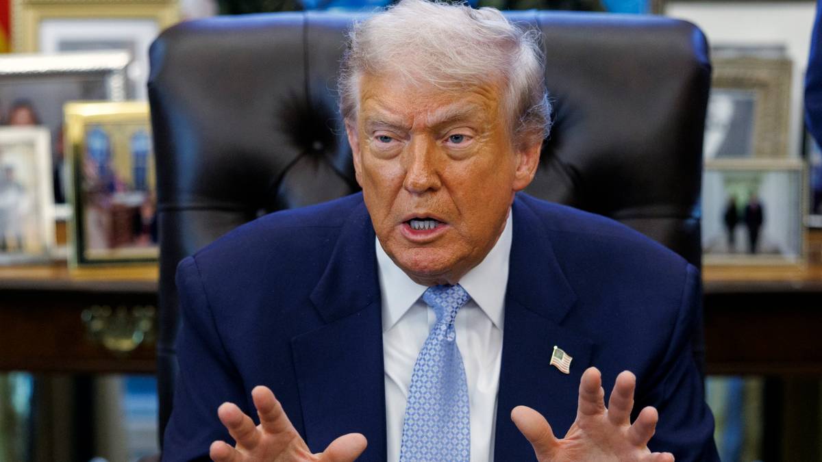 Donald Trump siedzi w fotelu i mówi, gestykulując rękami.