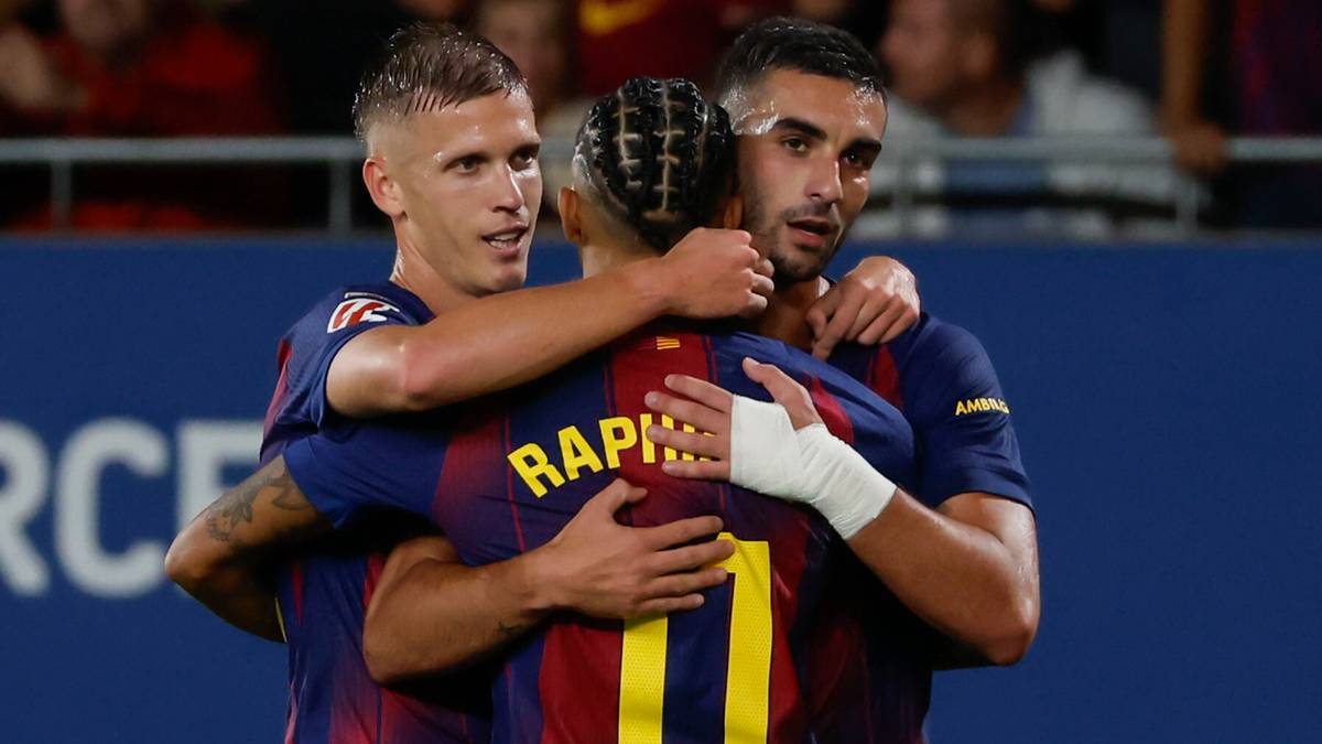 Trzech piłkarzy FC Barcelony w bordowo-granatowych strojach celebruje gola, obejmując się nawzajem.