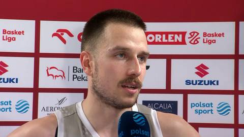 Mężczyzna w stroju sportowym udziela wywiadu przed ścianą z logotypami sponsor&oacute;w sportowych.