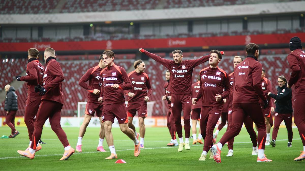 Piłkarze reprezentacji Polski w bordowych strojach ćwiczący na boisku piłkarskim.